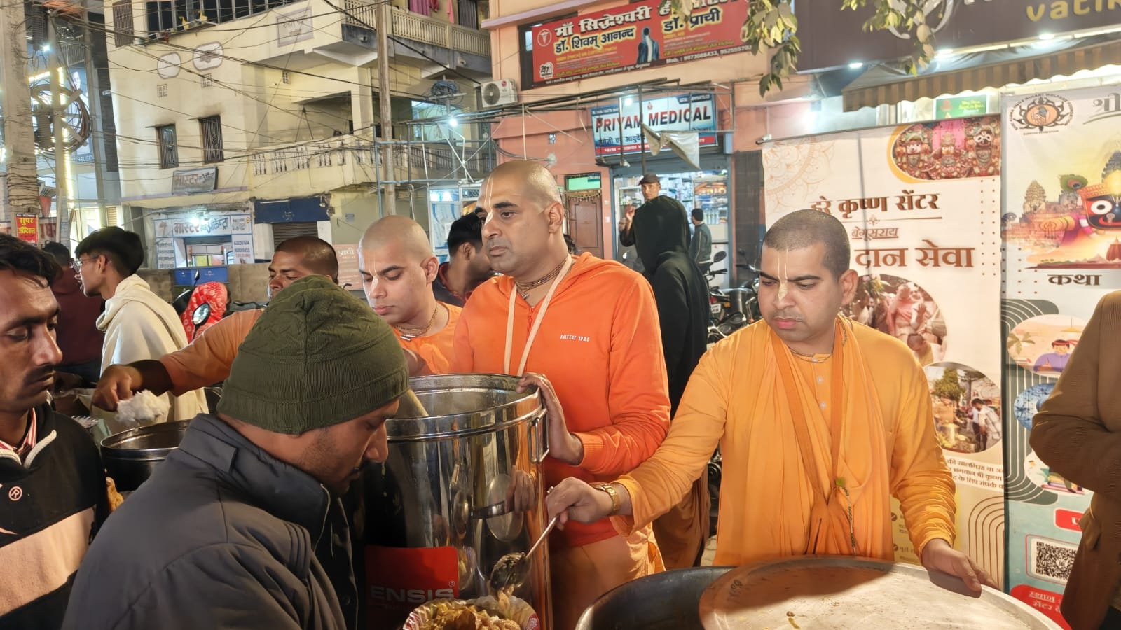Devotees serving prasadam to people on a busy street during Annadaan